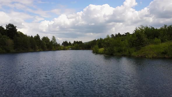 Drone shot over lake surrounded by trees forest in Svit, Poprad Slovakia, by the foot of the Tatra m alt
