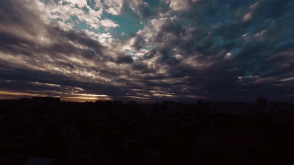 Time Lapse Over the City During Sunset, Beautiful Clouds, the Sun Breaks Through the Flying