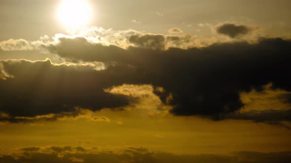 Dramatic Sunset with Sun Rays in Sky Through Orange Layered Clouds Timelapse alt