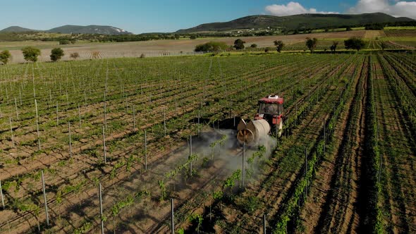 Chemicals used by agricultural tractor. Agricultural machinery works in the vineyards. alt