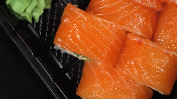 Sushi Rotates on a Plastic Box. Japanese Sushi Roll Set Philadelphia with Salmon alt