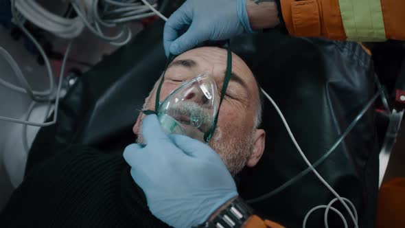 Crop Paramedics Putting Respirator on Patient alt