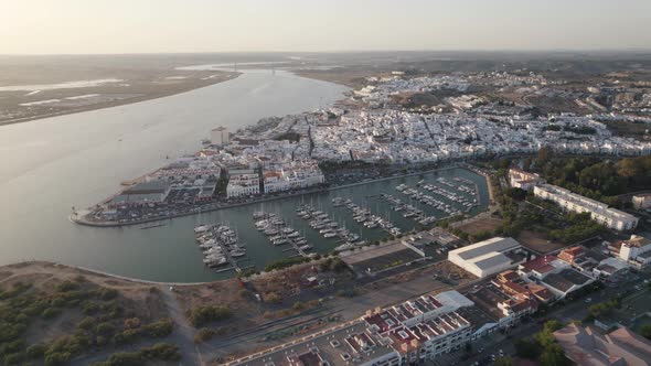 Aerial backwards view of coastal town of Ayamonte with its marina. Andalusia, Spain. alt