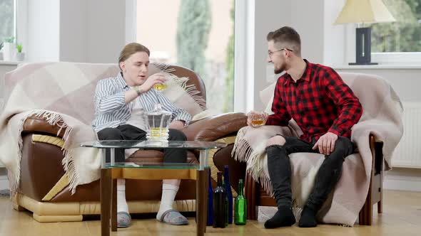 Wide Shot of Two Relaxed Caucasian Men Clinking Glasses and Talking Drinking Whiskey alt