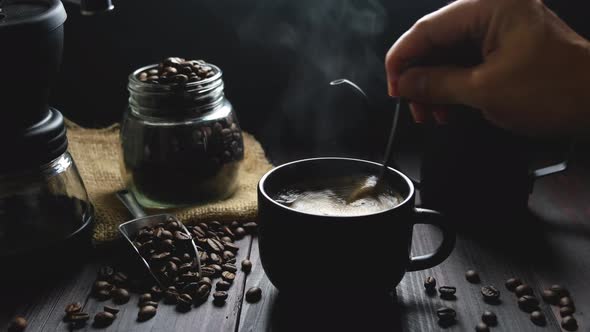 hot coffee in a black mug with drip coffee maker