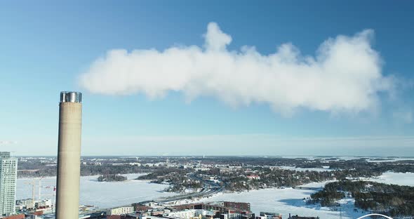 Aerial shot of a flue-gas stack in Winter, slowly pulling out. alt