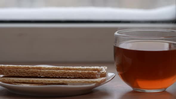 A Large Mug of Tea and Diet Bread in a Plate on the Windowsill in Winter