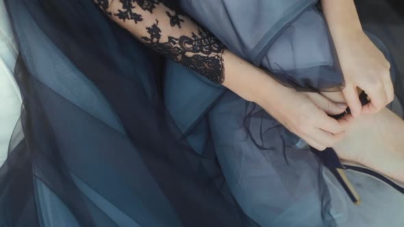 Bride in a blue dress puts on shoes. Wedding preparations alt