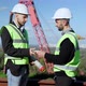 Foreman Paying Architect for Blueprint Shaking Hands Smiling on Sunny Day Outdoors - VideoHive Item for Sale
