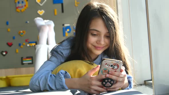 Happy Child is Mobile Teenage Girl Koristim a Smartphone Axes the Social Network Read Messages alt