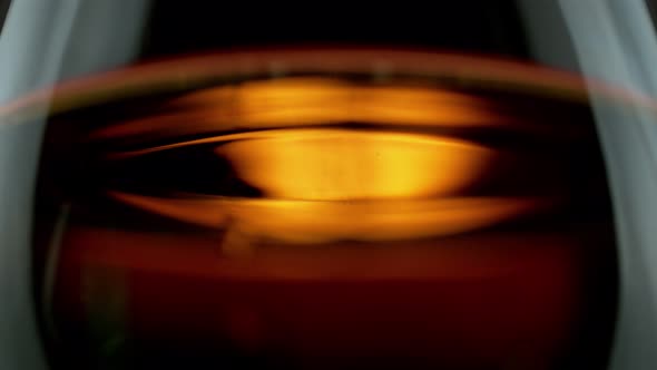 Super Slow Motion Detail Shot of Swirling Whiskey in Glass at 1000Fps alt