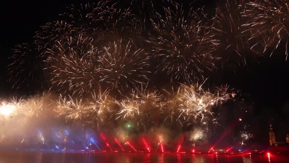 Festive Colorful Fireworks and Illumination in Dark Sky with Beautiful Reflection in Water