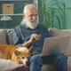 Handsome Elder Man with Lovely Dog Talking on Video Call on Laptop - VideoHive Item for Sale