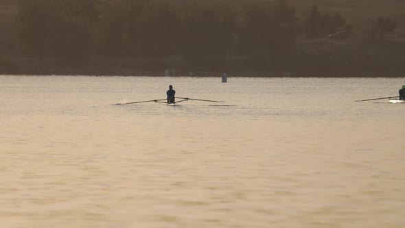 Two Male Rowers on Lake at Sunrise