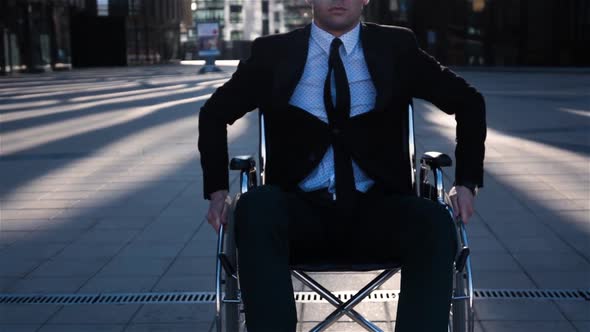 Cripple Businessman Move in Wheelchair on Camera Outdoor Near Business Centre. alt