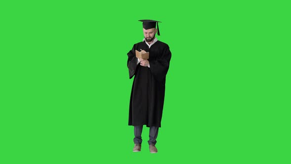Graduation Man Writing His Thoughts on a Green Screen, Chroma Key. alt