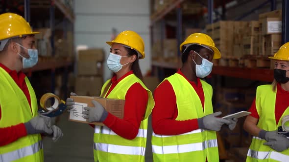 Multiracial people working in warehouse while wearing protective face masks