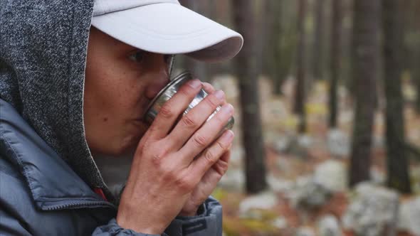Closeup Portrait of Young Woman Hiker Drinking Tea From Metal Cup in Forest