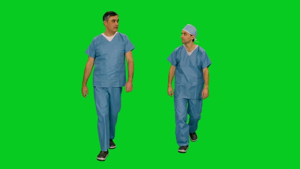 Two Surgeons Talking while Walking Against Green Screen