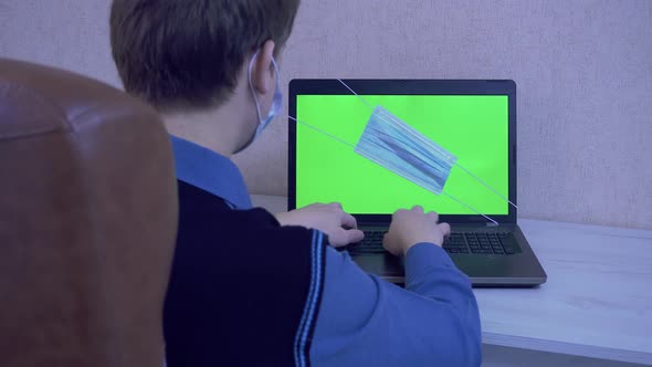 The Guy is Typing on the Laptop Keyboard a Message in Quarantine alt