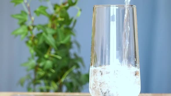 Drinking Healing Water is Poured Into a Glass Glass