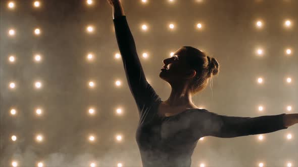 Silhouette of Ballerina in Black Tutu Is Dancing Ballet in the Dark Studio.