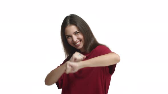Attractive Happy Woman in Red Tshirt Celebrating Dancing From Joy Standing Over White Background alt