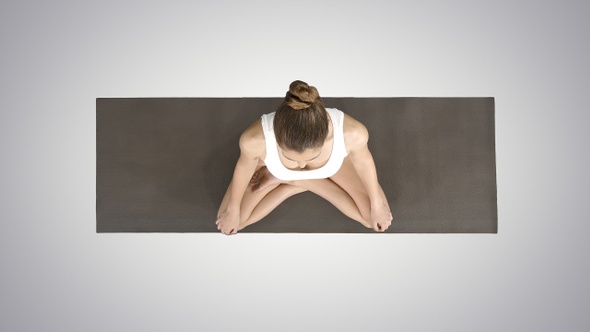 Young sporty woman practicing yoga sitting in lotus pose alt