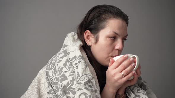 Portrait of Sick Tired Woman Patient with White Cup Sitting on Sofa