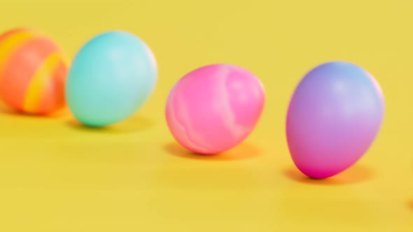 Cute multicolour Easter eggs rolling on a yellow background. Happy Easter. Joy. alt