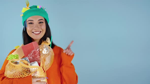 Woman with rubbish on herself sjowing by finger on the blue background.