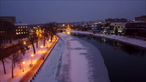 Fly above river, evening lights in Kharkiv city