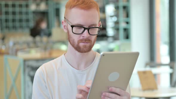 Portrait of Professional Redhead Man Using Digital Tablet  alt