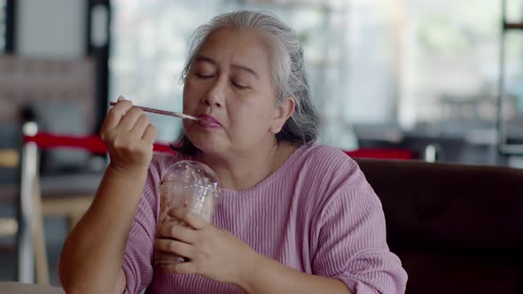 Senior woman enjoy eating whip cream in coffee shop