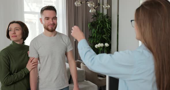 Close Up of Real Estate Agent is Giving Keys to Buyers of New Apartment alt