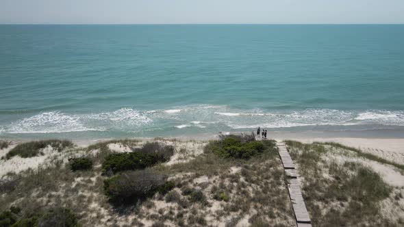 bald head island board walks over sand dunes toward sea Aerial alt