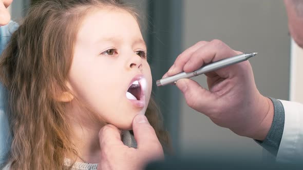 Doctor watching little patient's throat