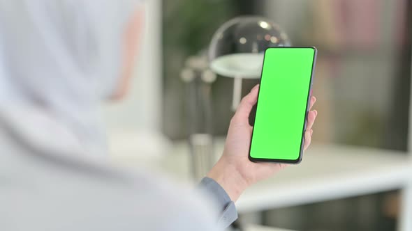 Rear View of Arab Woman Looking at Smartphone with Chroma Key Screen alt