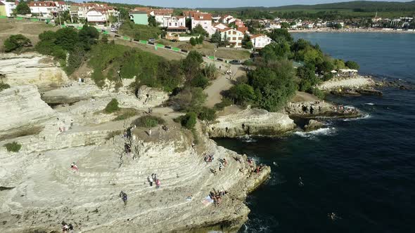 Rocks in The Sea and People Swimming in The Sea alt