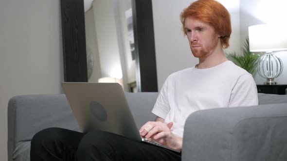 Casual Redhead Man Working with Laptop in His Lap alt