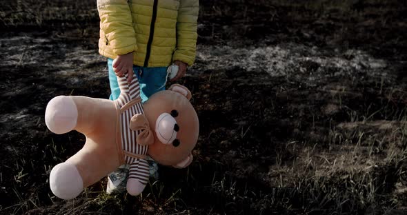 Girl Child in Clothes in the Colors of the Ukrainian Flag on Earth Destroyed alt