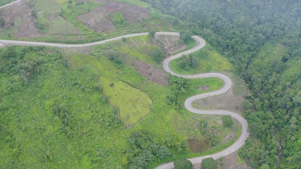 Aerial view of cars driving on curved, zigzag curve road or street on mountain hill