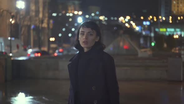 Melancholic Emotive Caucasian Female Walking In The City At Night While It Rains alt