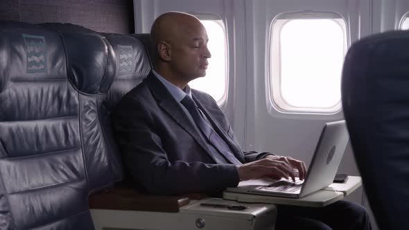 Businessman using laptop computer on airplane
