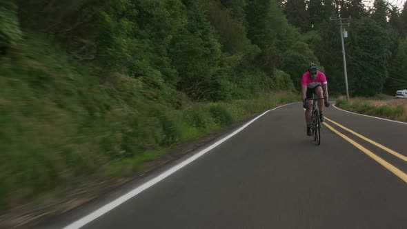 Tracking shot of a male cyclist on country road.  Fully released for commercial use.