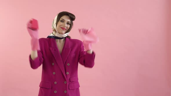 A Woman in Rubber Gloves Holds a Dish Sponge and a Rag in Her Hands and Dances