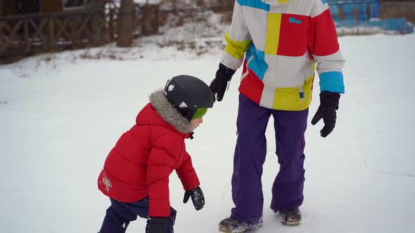 Young Man Snowboard Instructor Tiches Little Boy How To Ride a Snowboard, Winter Activities Concept alt
