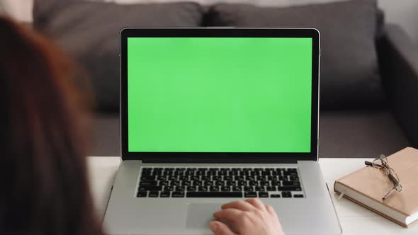 Over the Shoulder Shot of Caucasian Woman Looking at Green Screen Chroma Key