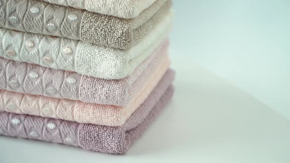Stack of Cotton Terry Clean Folded Towels Rotate on Board. Health, Hygiene and Cleanliness Concept.