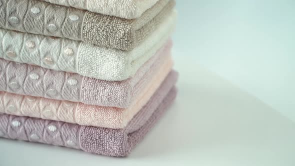 Stack of Cotton Terry Clean Folded Towels Rotate on Board. Health, Hygiene and Cleanliness Concept. alt